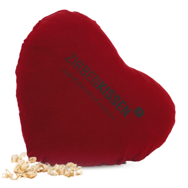 ZirbenKissen in Herzform mit Baumwollstoffüberzug und gefüllt mit ZirbenFlocken in der Farbe Rot, umgeben von ZirbenFlocken